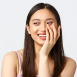 woman smiling with hand on her face