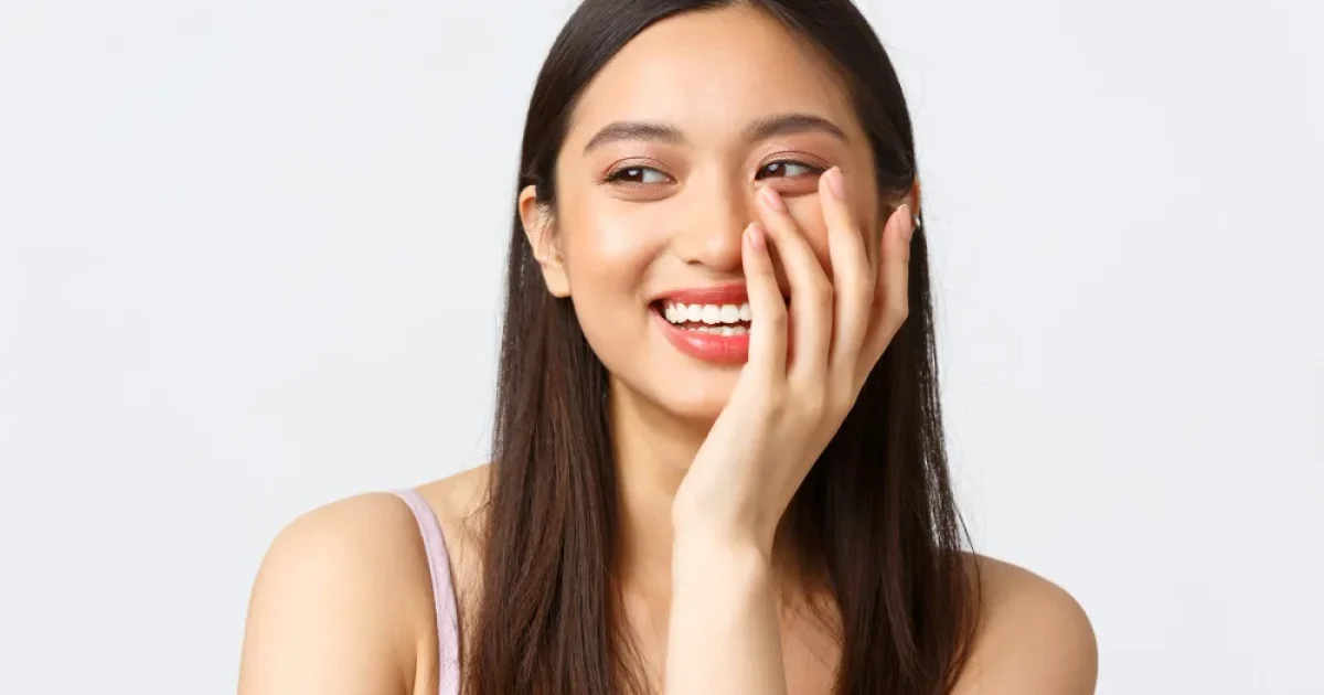 woman smiling with hand on her face