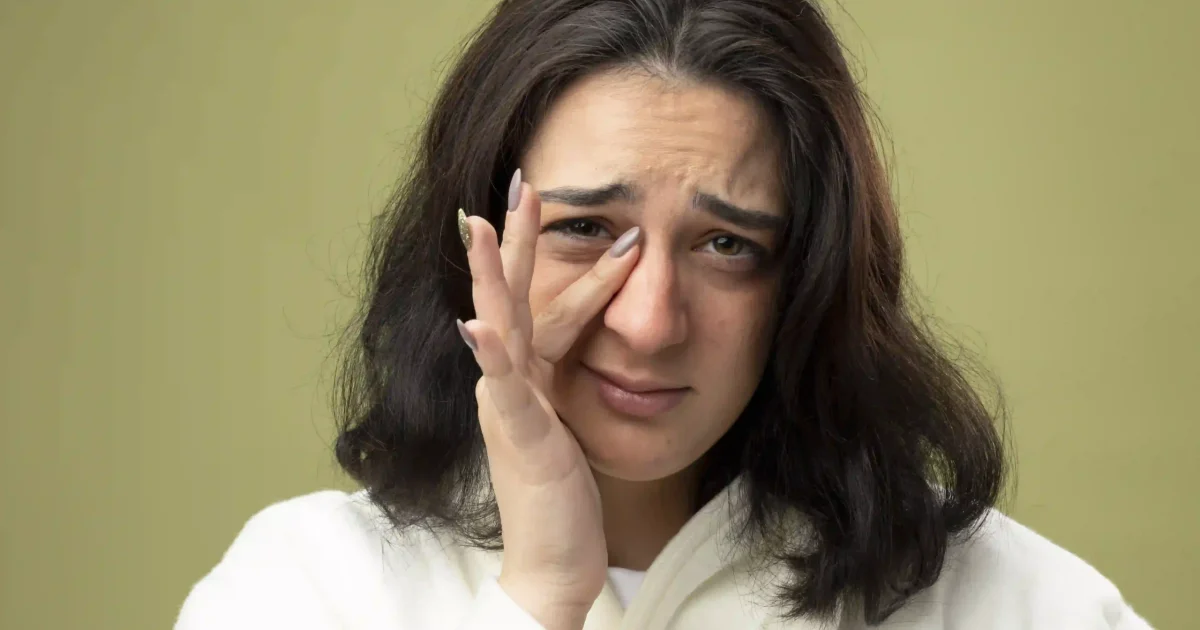 woman covering her eye bag with her finger
